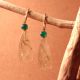 Boucles d'oreilles en or Jaune 18K fabriquées à Genève, ville de la haute joaillerie.Elles sont serties d'émeraudes cabochons et de quartz rutiles